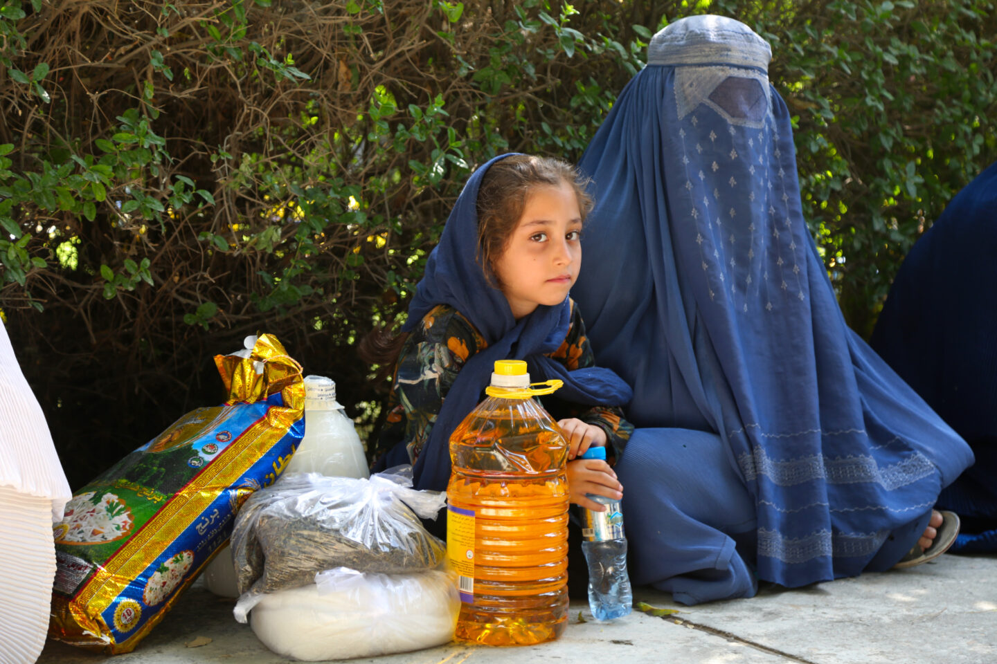 Afghan mother and child receiving emergency relief from STEP