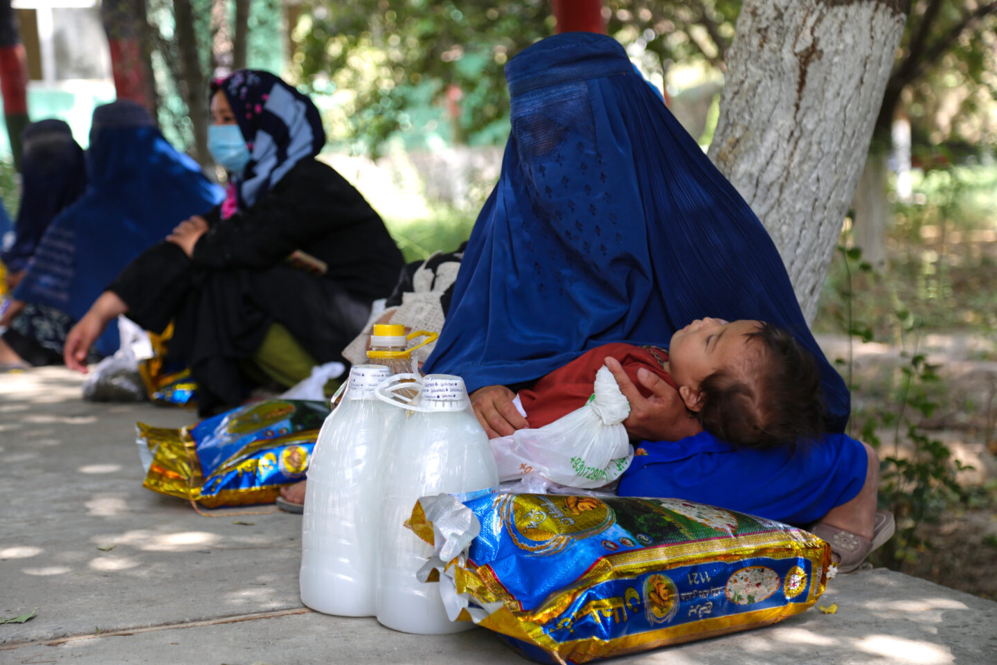 Afghan mother and child receiving emergency relief from STEP
